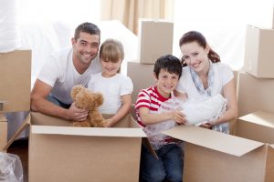 Photo of a man unpacking boxes with his children